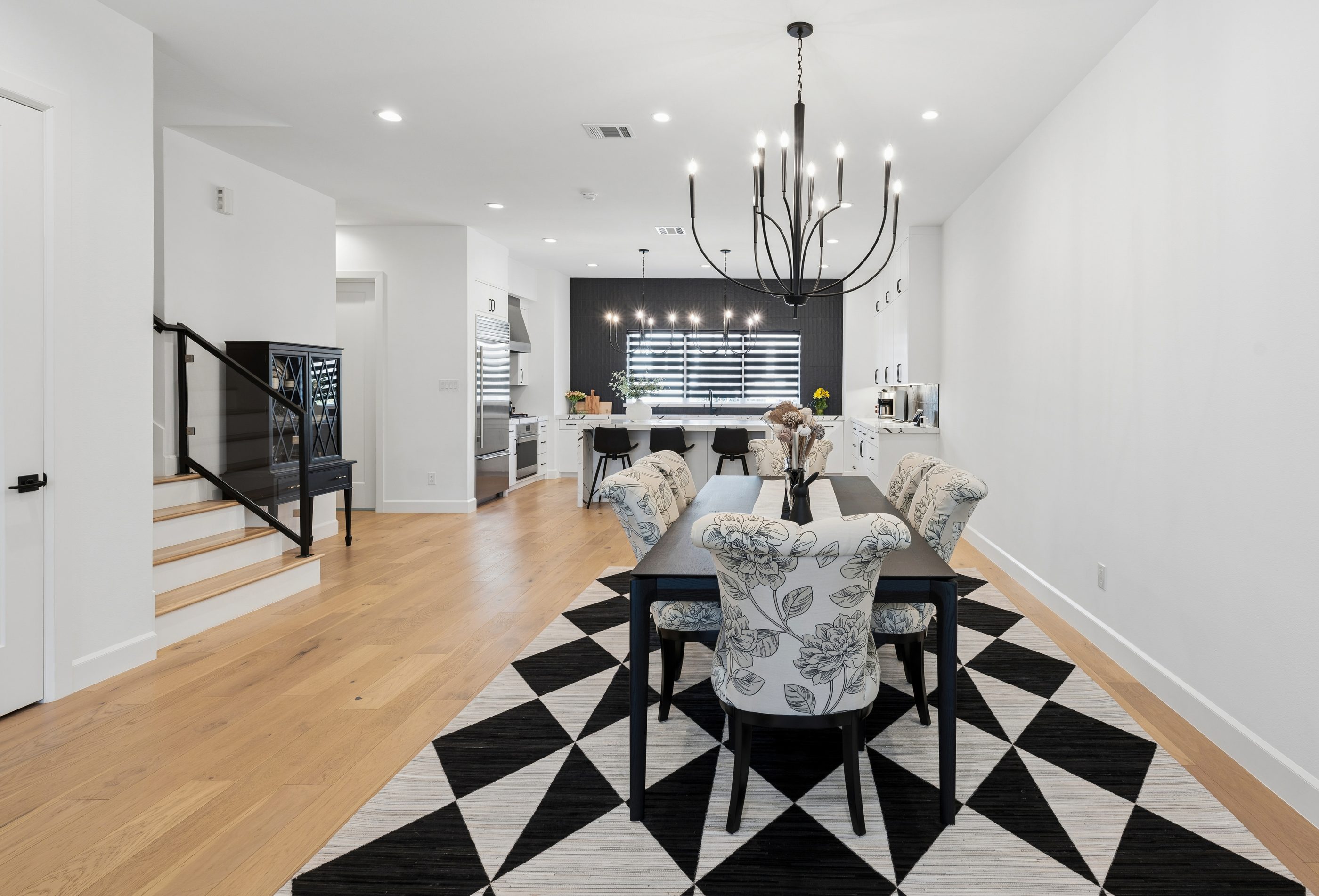 Formal dining with chandelier and kitchen beyond